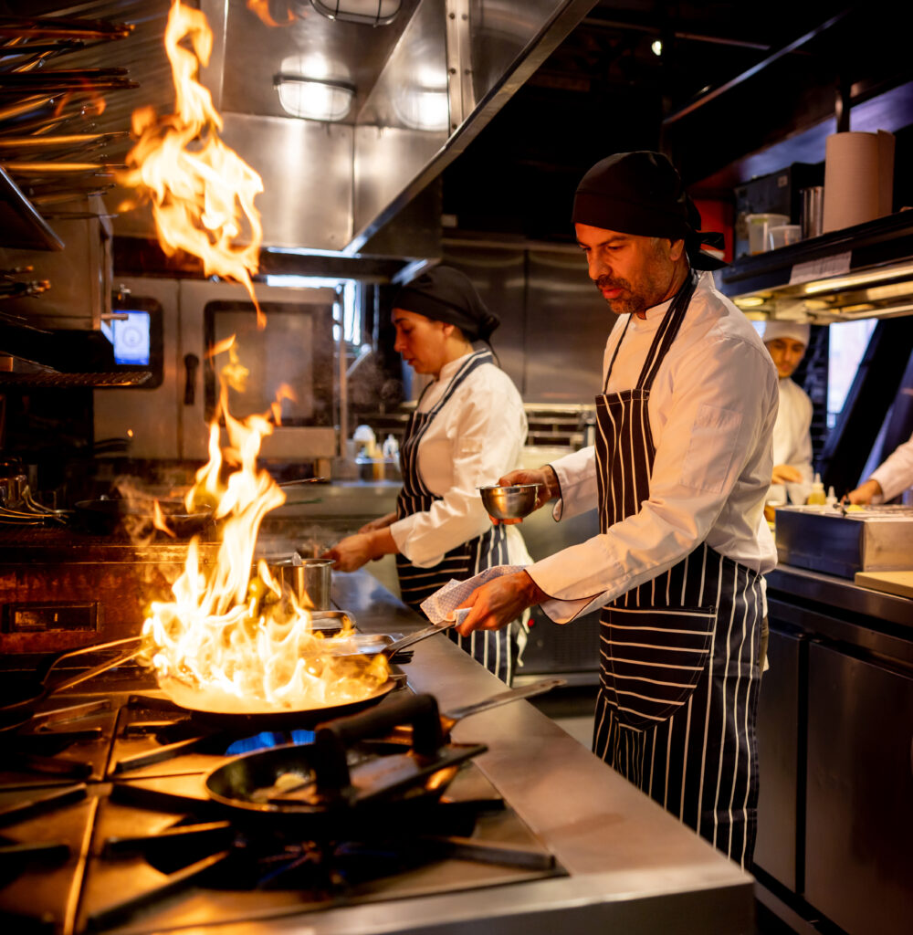 Chef cooking at a restaurant and flaming the food